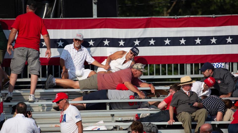 PHOTO: Trump supporters are seen laying in the stands after guns were fired at Republican candidate Donald Trump at a campaign event in Butler, Pennsylvania, July 13, 2024.  (Rebecca Droke/AFP via Getty Images)