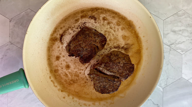 steaks in frying pan