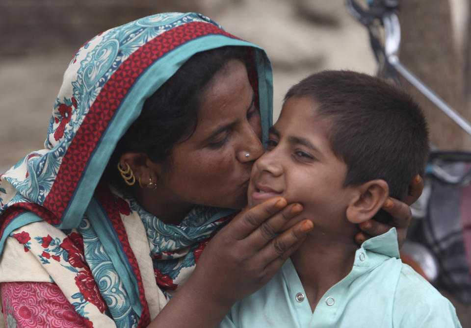 A Pakistani mother kisses her son Ali Raza, 10, infected with HIV in a village near Ratodero, a small town in southern province of Sindh in Pakistan, Thursday, May 16, 2019. Officials say about 500 people, mostly children, have tested positive for HIV, the virus that causes AIDS, in a southern Pakistani provincial district. A local doctor who has AIDS has since been arrested and is being investigated for possibly intentionally infecting patients. (AP Photo/Fareed Khan)