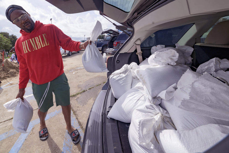 Jawan Williams loads his vehicle with sandbags before landfall of Hurricane Ida at the Frederick Sigur Civic Center in Chalmette, La., which is part of the Greater New Orleans metropolitan area, Saturday, Aug. 28, 2021. The storm is expected to bring winds as high as 140 mph when it slams ashore late Sunday. (AP Photo/Matthew Hinton)