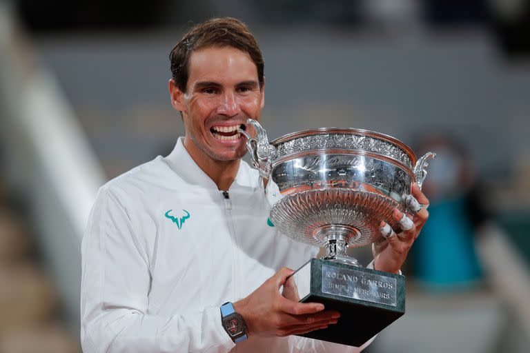 El español Rafael Nadal muerde el trofeo mientras celebra ganar el partido final del torneo de tenis Abierto de Francia contra el serbio Novak Djokovic en tres sets, 6-0, 6-2, 7-5, en el estadio de Roland Garros en París, Francia, el domingo. , 11 de octubre de 2020