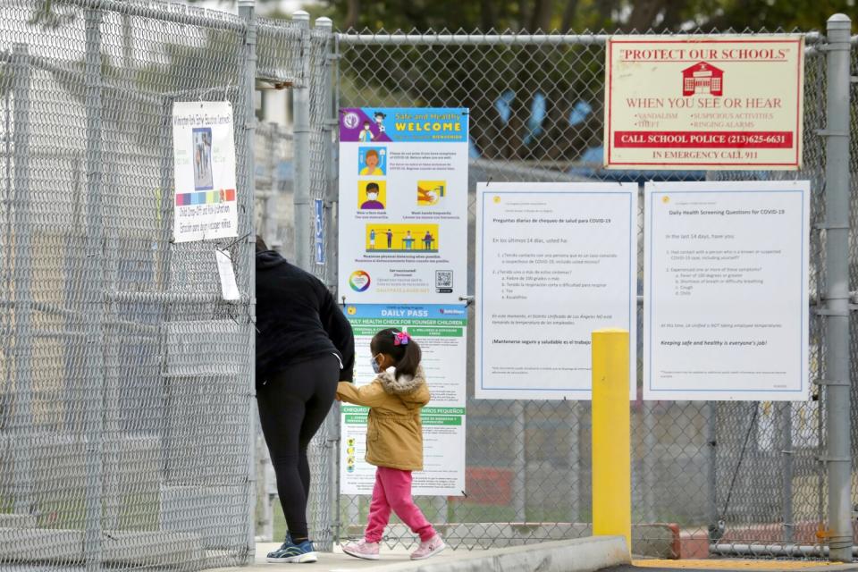 A woman drops off a young girl at school