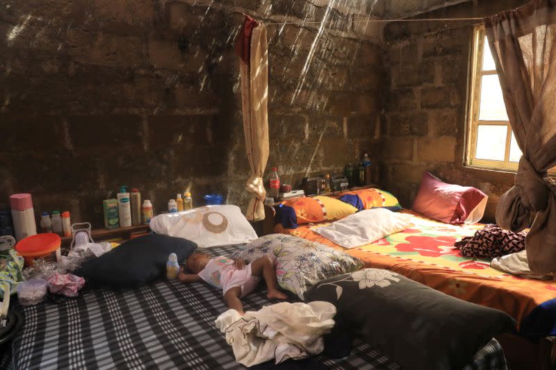 A baby sleeps on a bed at a shelter for the displaced inhibitants of the Okun glass community in Lagos