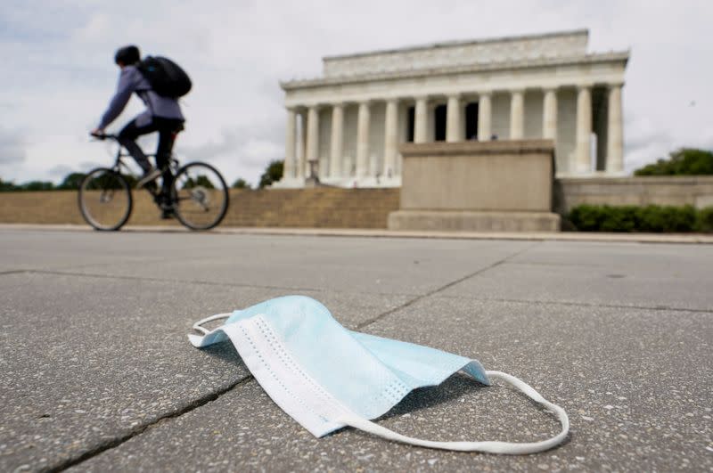 FILE PHOTO: A cyclist passes a discarded face mask in front of the Lincoln Memorial during the coronavirus disease (COVID-19) pandemic in Washington