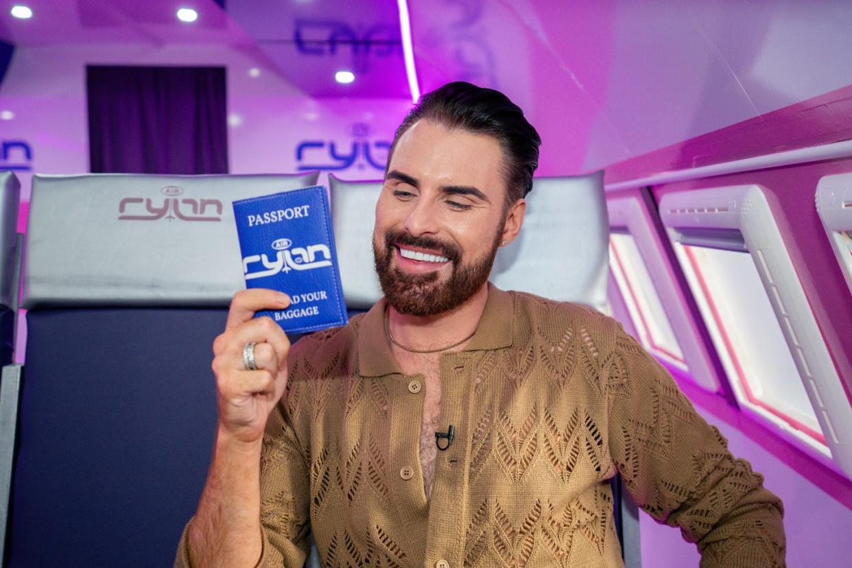 rylan clark holds up a blue passport sized wallet for air rylan