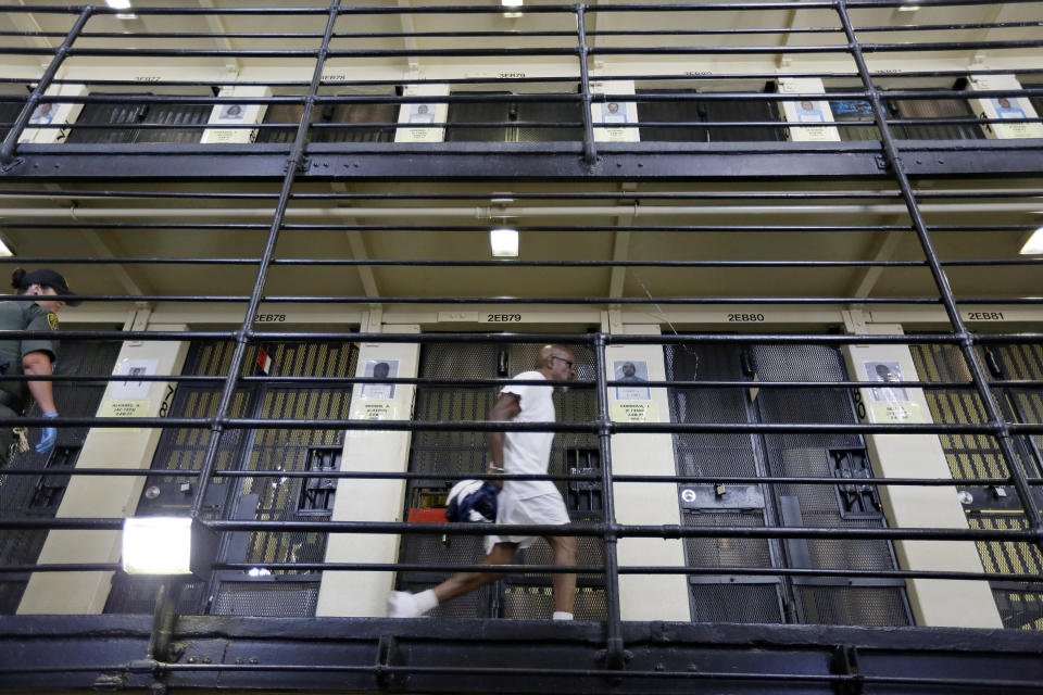 FILE - In this Aug. 16, 2016 file photo, a condemned inmate walks along the east block of death row at San Quentin State Prison in San Quentin, Calif. Gov. Gavin Newsom is expected to sign a moratorium on the death penalty in California Wednesday, March 13, 2019. (AP Photo/Eric Risberg, File)