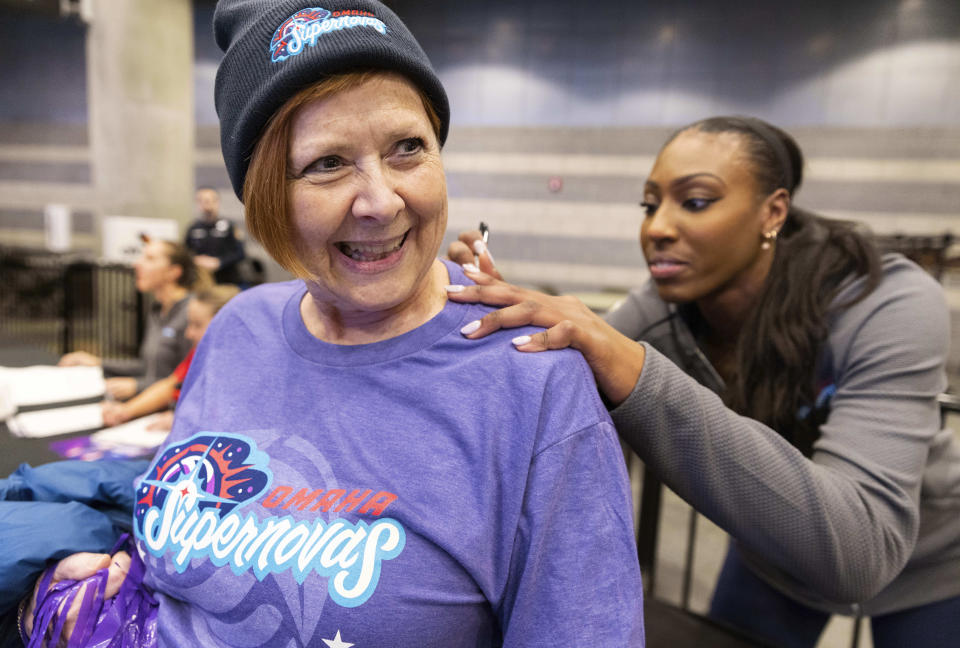 Omaha Supernovas' Nia Kai Reed, right, autographs a shirt for Julie Spearin of Grand Rapids, Mich., following their five set loss to the Atlanta Vibe in a Pro Volleyball Federation game Wednesday, Jan. 24, 2024, in Omaha, Neb. Spearin's niece, Kendall White, also plays for the Supernovas. (AP Photo/Rebecca S. Gratz)