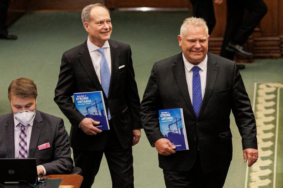 Premier Doug Ford and finance minister Peter Bethlenfalvy enter the chamber of the Ontario legislature with copies of the provincial budget, at Queen’s Park, in Toronto, on March 23, 2023.