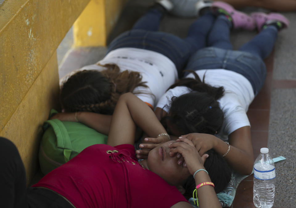 Migrant women sleep after camping out on the Gateway International Bridge that connects downtown Matamoros, Mexico with Brownsville, Thursday, Oct. 10, 2019. Migrants wanting to request asylum camped out on the international bridge leading from Mexico into Brownsville, Texas, causing a closure of the span. (AP Photo/Fernando Llano)