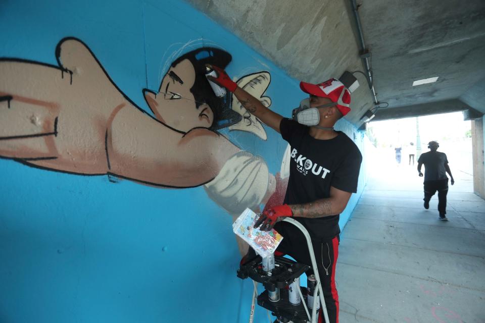 The BLKOUT Mural Festival hosted local and national artists along with some from the International scene to work on 25 murals around metro Detroit Monday, September 11, 2023. Torrence Jayy from Detroit works on his mural Roses 2 Patricia along Woodward Ave.