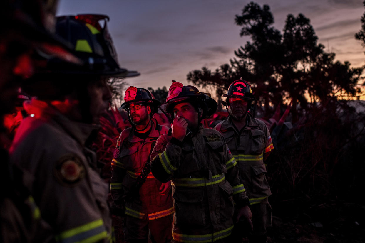 Bomberos trabajando el domingo por la noche en el jardín botánico nacional de Chile, donde los incendios forestales amenazaron especies vegetales raras. (Cristobal Olivares/The New York Times)