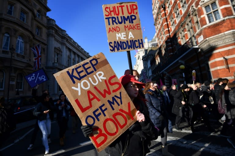 Protesters hold placards during the Women's March in London on January 21, 2017 as part of a global day of protests against new US President Donald Trump