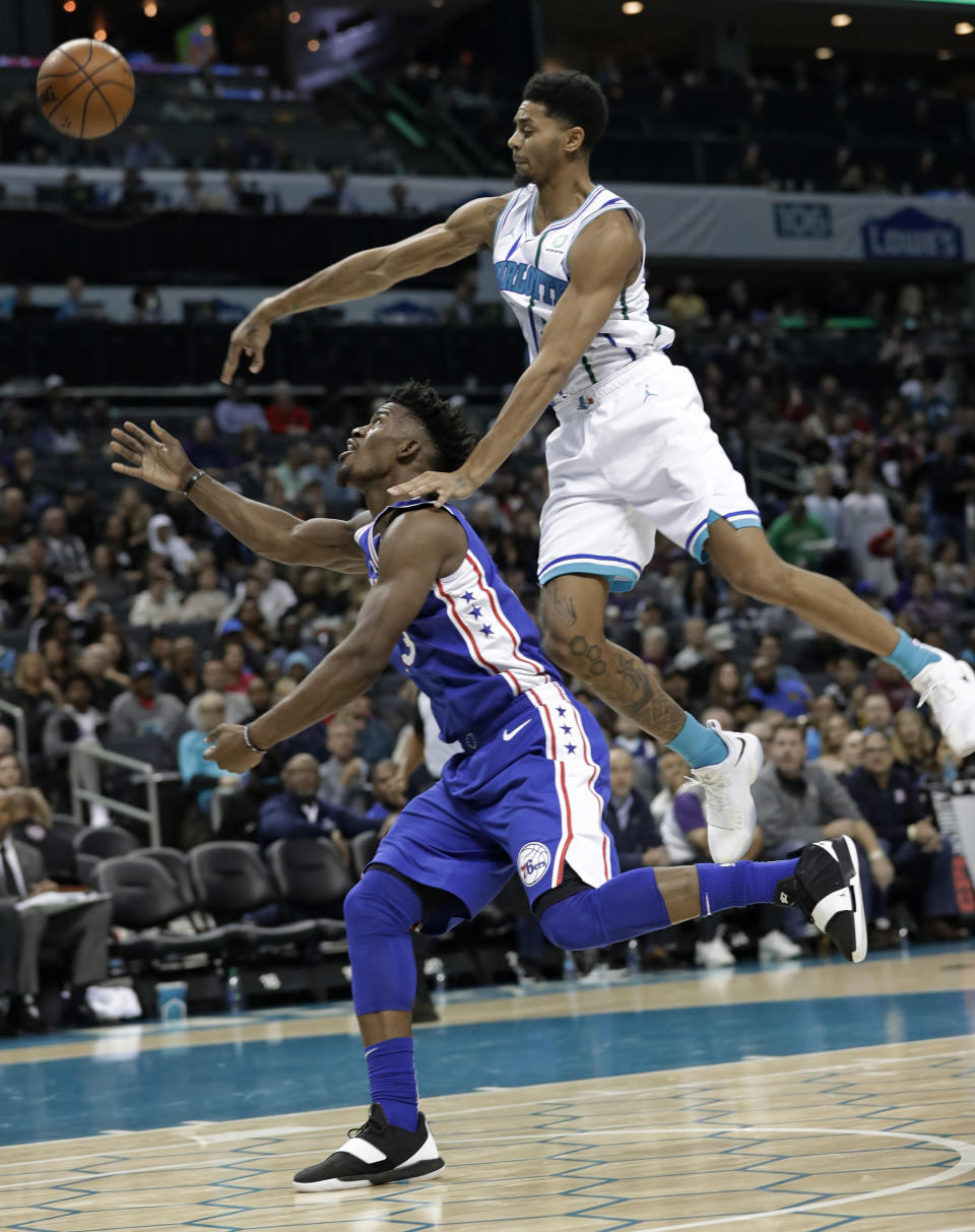 Philadelphia 76ers' Jimmy Butler, left, drives past Charlotte Hornets' Jeremy Lamb during the second half of an NBA basketball game in Charlotte, N.C., Saturday, Nov. 17, 2018. (AP Photo/Chuck Burton)