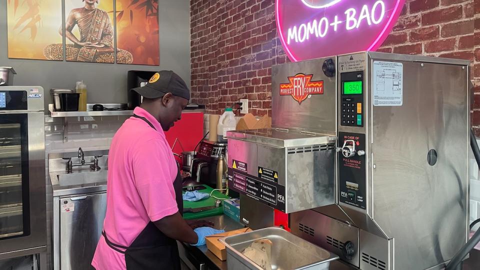 SK waits for a batch of momos to steam at his kiosk. SK came to Canada from Kenya, and says he'd like to open his own food business that mixes Kenyan cuisine with momos and bau.
