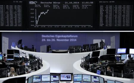 Traders are pictured at their desks in front of the DAX board at the Frankfurt stock exchange October 21, 2014. REUTERS/Remote/Stringer