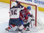 Columbus Blue Jackets right wing Kirill Marchenko (86) tries to remove Montreal Canadiens left wing Rafael Harvey-Pinard (49) from in front of Blue Jackets goaltender Elvis Merzlikins (90) during second-period NHL hockey game action in Montreal, Saturday, March 25, 2023. (Peter McCabe/The Canadian Press via AP)