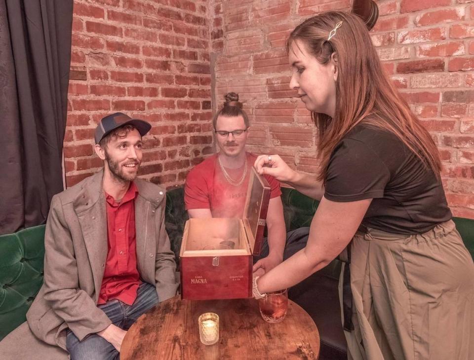 Jessica Stockton served drinks from the Smoking Box to Bobby Burk, left, and Ryan Newhouse. Roy Inman/Special to The Star