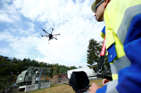 A worker operates a drone to survey high-voltage power lines of electric company Westnetz near Wilnsdorf, Germany, July 11, 2018. REUTERS/Ralph Orlowski