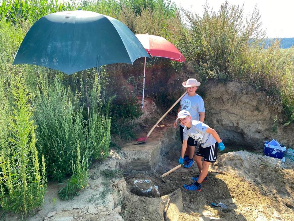 The brothers, 9-year-old Constantin and 10-year-old Alexander, dig in a gravel area.