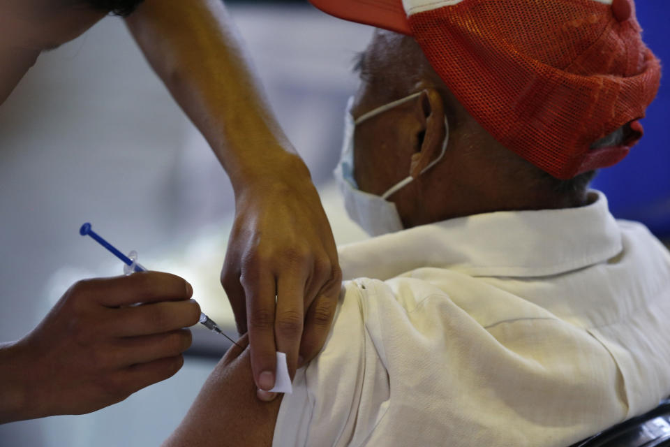 A medical worker gives a man a shot of the Russian COVID-19 vaccine Sputnik V, as part of a mass vaccination campaign for Mexicans over age 60, at Palacio de los Deportes, in Mexico City, Wednesday, Feb. 24, 2021. (AP Photo/Rebecca Blackwell)