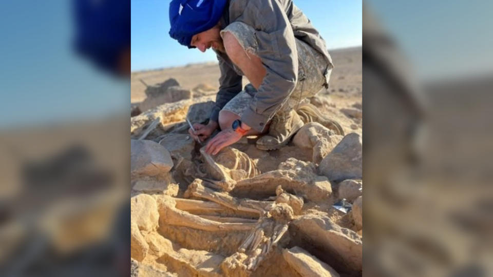 A man in a headscarf excavates the stony ground.