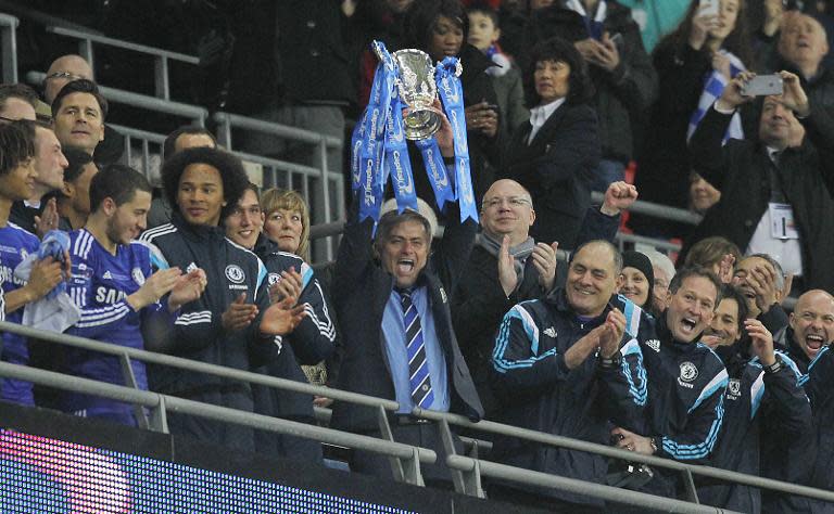 Chelsea's manager Jose Mourinho lifts the trophy during the presentation after Chelsea won the League Cup final football match against Tottenham Hotspur at Wembley Stadium in London on March 1, 2015