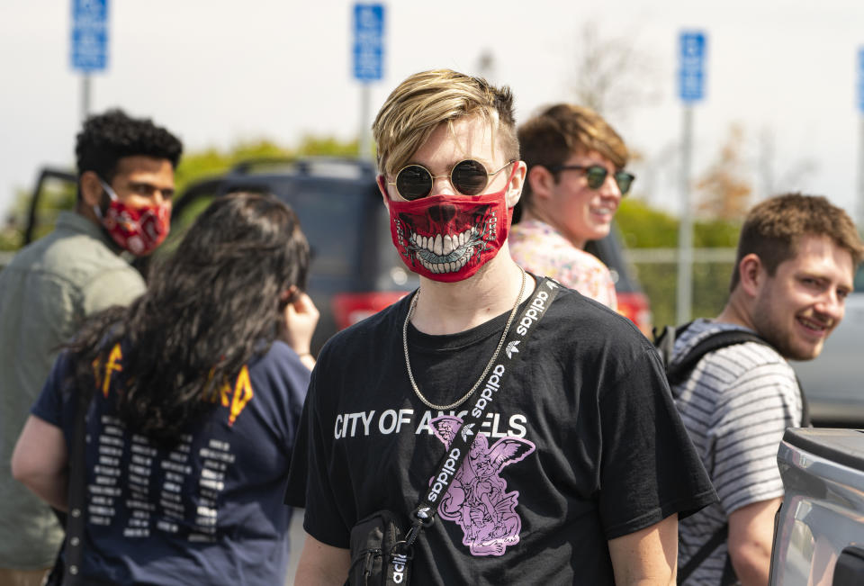 Student Sander Albertson, from Minnesota, wears a face mask outdoors with his friends at the Griffith Observatory in Los Angeles, Monday, May 17, 2021. California is keeping its rules for wearing face masks in place until the state more broadly lifts its pandemic restrictions on June 15. (AP Photo/Damian Dovarganes)