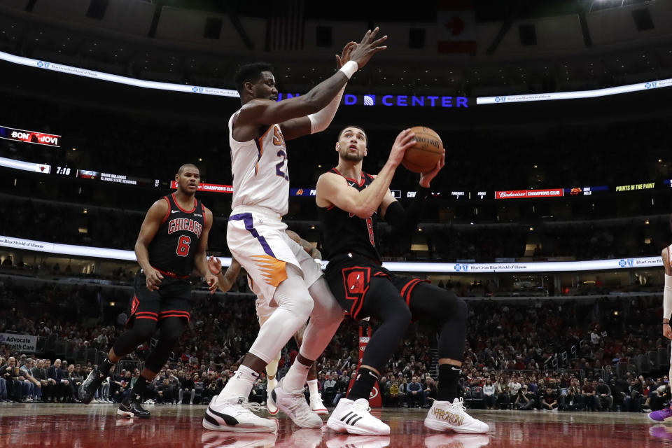 Chicago Bulls guard Zach LaVine, right, looks to the basket against Phoenix Suns center Deandre Ayton during the first half of an NBA basketball game in Chicago, Saturday, Feb. 22, 2020. (AP Photo/Nam Y. Huh)