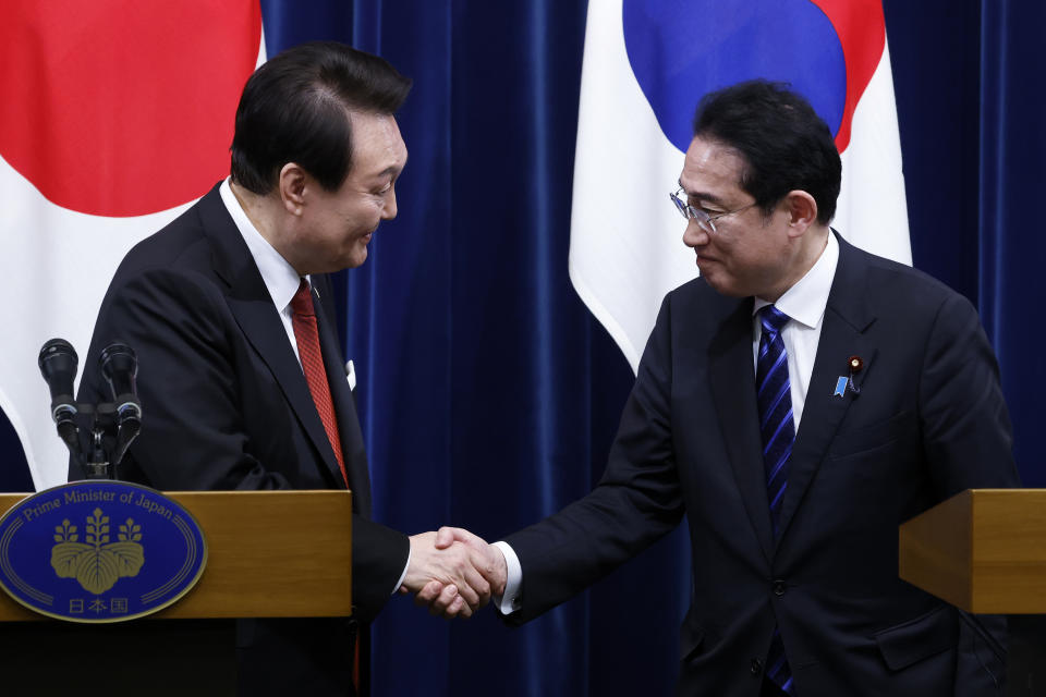 South Korean President Yoon Suk Yeol, left, and Japanese Prime Minister Fumio Kishida, right, shake hands following a joint news conference at the prime minister's official residence in Tokyo, Japan, Thursday, March 16, 2023. (Kiyoshi Ota/Pool Photo via AP)