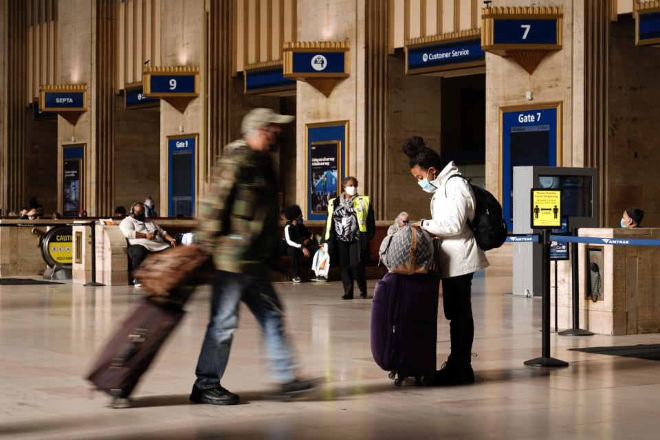 Travelers make their way through the 30th Street Station ahead of the Thanksgiving holiday, Friday, Nov. 20, 2020, in Philadelphia. With the coronavirus surging out of control, the nation's top public health agency pleaded with Americans not to travel for Thanksgiving and not to spend the holiday with people from outside their household. (AP Photo/Matt Slocum)