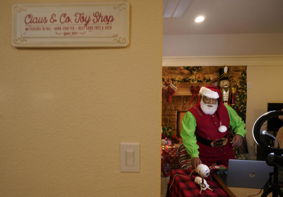 Larry Jefferson prepares to portray Santa Claus for virtual visits with kids from his home in Duncanville, Texas, on Dec. 9, 2020. In this socially distant holiday season, Santa Claus is still coming to towns (and shopping malls) across America but with a few 2020 rules in effect. (AP Photo/LM Otero)