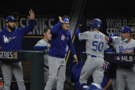 Los Angeles Dodgers' Mookie Betts celebrates at the dugout after scoring on a hit by Corey Seager during the first inning in Game 5 of the baseball World Series against the Tampa Bay Rays Sunday, Oct. 25, 2020, in Arlington, Texas. (AP Photo/Tony Gutierrez)