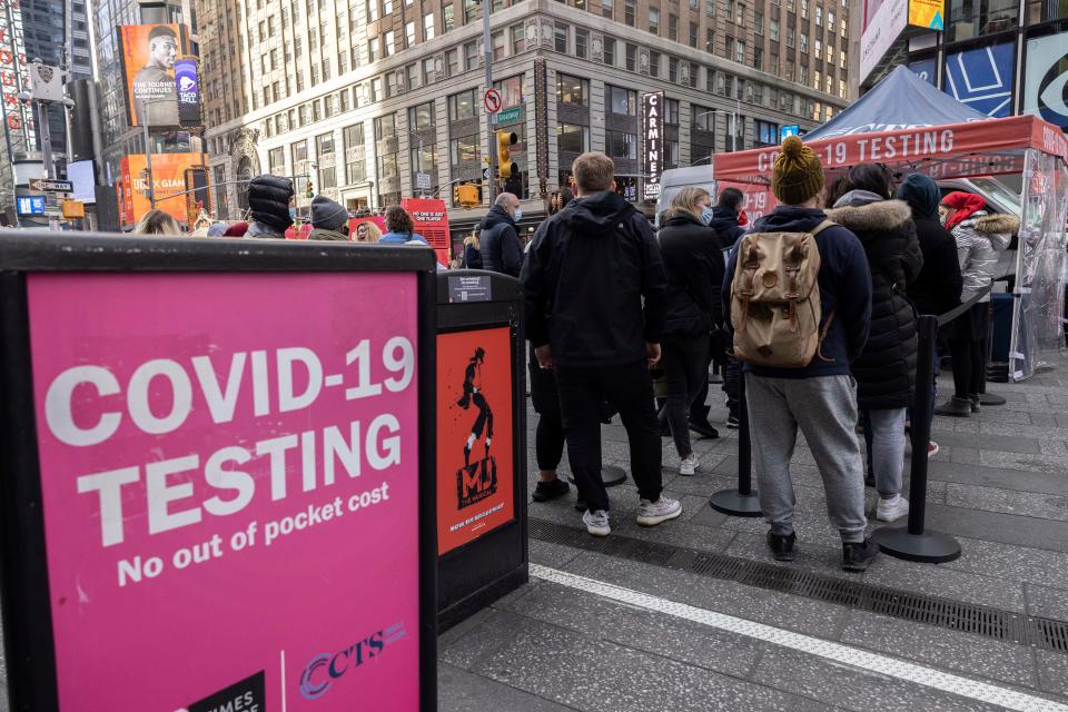 People wait in line to get tested for COVID-19 at a mobile testing site in Times Square on Friday, Dec. 17, 2021, in New York.