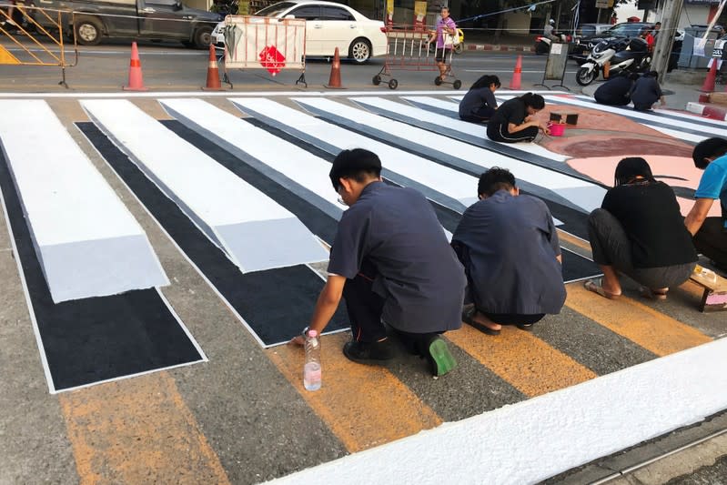 People paint a 3D pedestrian crossing in Bangkok