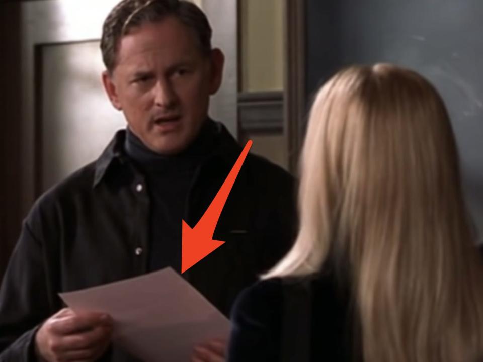 red arrow pointing at callahan holding elle's pink resume in a scene from legally blonde