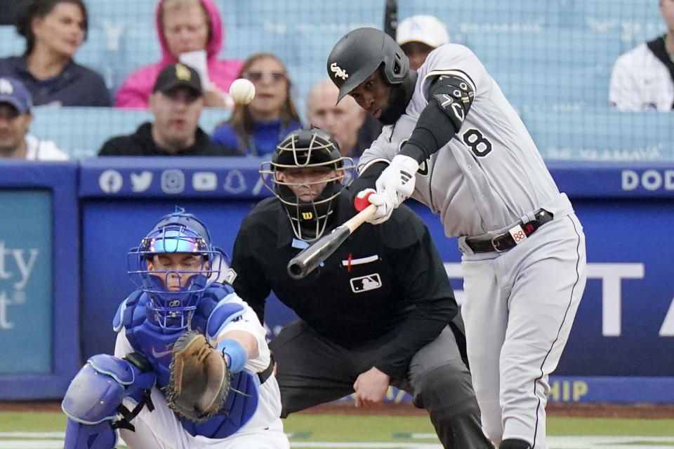 Chicago White Sox's Luis Robert Jr., right, hits a solo home run as Los Angeles Dodgers catcher Will Smith, left, and home plate umpire Jacob Metz watch during the first inning of a baseball game Thursday, June 15, 2023, in Los Angeles. (AP Photo/Mark J. Terrill)
