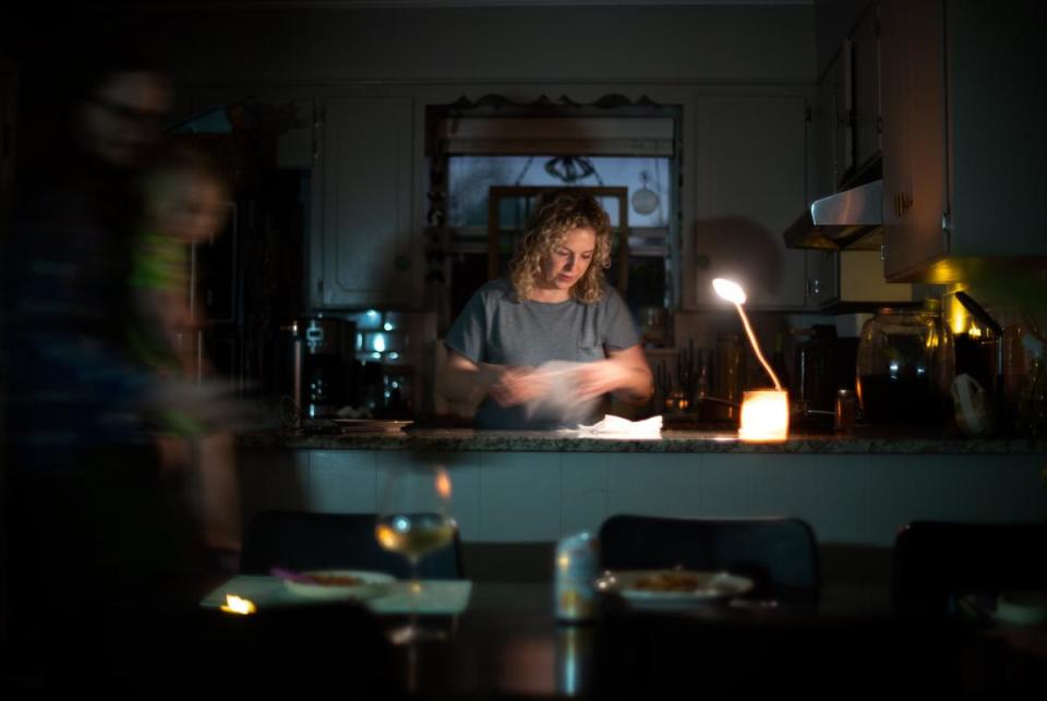 Whitney Morrow serves dinner, cooked on a propane camping stove, by a battery-powered desk light used for working from home in Wooten, Austin on Feb. 6, 2023.