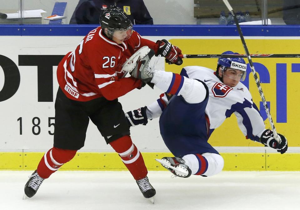 Canada's Curtis Lazar (L) checks Slovakia's Jakub Predajniansky during the first period of their IIHF World Junior Championship ice hockey game in Malmo, Sweden, December 30, 2013. REUTERS/Alexander Demianchuk (SWEDEN - Tags: SPORT ICE HOCKEY)