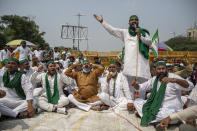 Indian farmers shout slogans as they block a highway during a protest in Noida, India, Friday, Sept. 25, 2020. Hundreds of Indian farmers took to the streets on Friday protesting new laws that the government says will boost growth in the farming sector through private investments, but they fear these are likely to be exploited by private players for buying their crops cheaply. (AP Photo/Altaf Qadri)