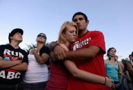 Lonnie Delgado (R) hugs Heaven Leek during a prayer for victims at the Century 16 movie theatre where a gunman attacked movie goers during an early morning screening of the new Batman movie, 'The Dark Knight Rises' on July 20, 2012 in Aurora, outside of Denver, Colorado. According to reports, 12 people were killed and 59 wounded when James Holmes allegedly opened fire inside the theater. Police have Holmes 24, of North Aurora, in custody. (Photo by Kevork Djansezian/Getty Images)