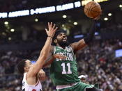 Boston Celtics guard Kyrie Irving (11) makes a basket as Toronto Raptors guard Fred VanVleet (23) defends during second-half NBA basketball game action in Toronto, Friday, Oct. 19, 2018. (Frank Gunn/The Canadian Press via AP)