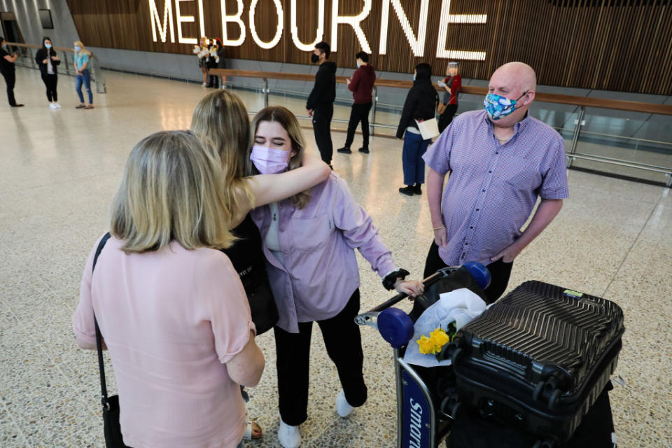 A family is reunited as an international traveler walks through at Melbourne Airport International arrivals hall in Melbourne, Australia. 