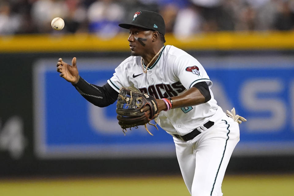 Arizona Diamondbacks' Geraldo Perdomo can't field a base hit by Los Angeles Dodgers' Gavin Lux during the third inning of a baseball game, Thursday, May 26, 2022, in Phoenix. (AP Photo/Matt York)