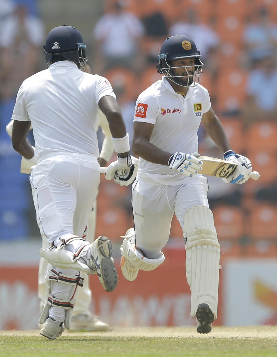 Sri Lanka's Dimuth Karunaratne, right, and Angelo Mathews run between wickets during the fourth day of the second test cricket match between Sri Lanka and England in Pallekele, Sri Lanka, Saturday, Nov. 17, 2018. (AP Photo/Eranga Jayawardena)