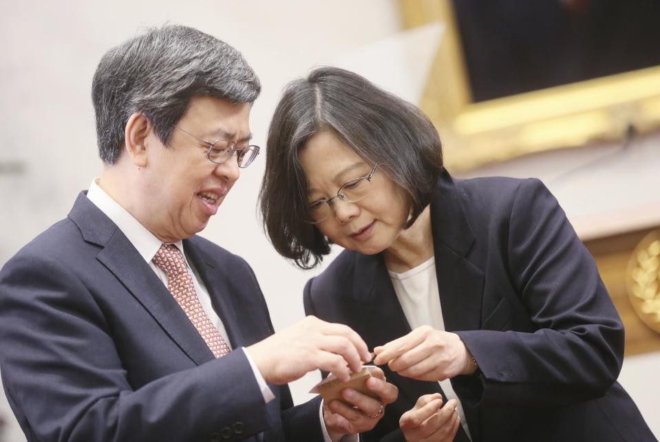 In this photo released by the Taiwan Presidential Office, President Tsai Ing-wen, right, and Vice President Chen Chien-jen look through name cards of journalists attending an international press conference at the presidential office, Saturday, Dec. 31, 2016, in Taipei, Taiwan. President Tsai urged China to engage in "calm and rational" dialogue to maintain peace, vowing not to give in to Beijing's recent moves to "threaten and intimidate" the self-ruled island. (Taiwan Presidential Office via AP)