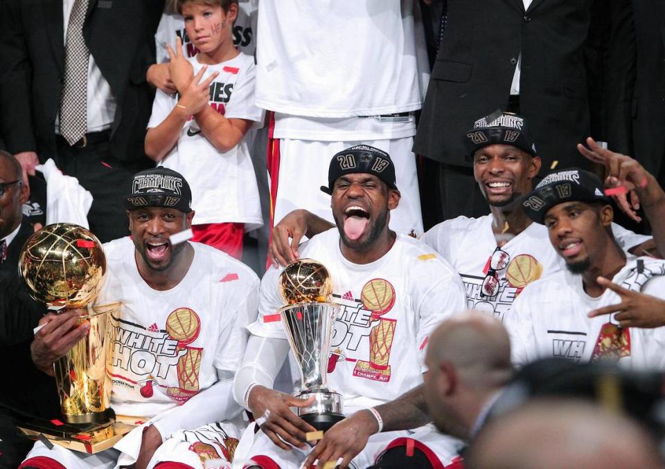 Dwyane Wade, LeBron James, and Chris Bosh celebrate with both trophies after the Heat won Game 7 of the 2013 NBA Finals at AmericanAirlines Arena in Miami, Florida on Thursday, June 20, 2013.