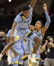 Marquette guard Kam Jones (1) celebrates with forward Olivier-Maxence Prosper (12) and guard Greg Elliott (5) after their team defeated Villanova in an NCAA college basketball game, Wednesday, Jan. 19, 2022, in Villanova, Pa. (AP Photo/Laurence Kesterson)