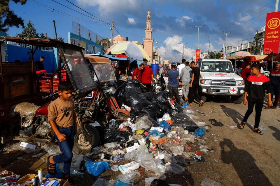 PHOTO: Palestinians walk past piles of garbage that threaten to spark an environmental catastrophe in Khan Younis in the southern Gaza Strip, Oct. 16, 2023. (Mohammed Salem/Reuters)