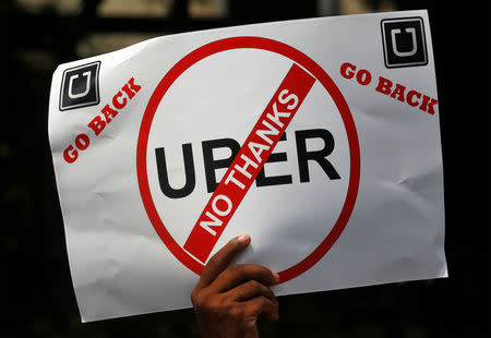 A man holds a placard during a protest against Ola and Uber outside Uber's head office in Mumbai, India, October 22, 2018. REUTERS/Francis Mascarenhas