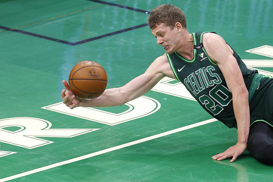 BOSTON, MASSACHUSETTS - MARCH 31: Moritz Wagner #20 of the Boston Celtics dives to keep the ball inbounds during the second half of the game against the Dallas Mavericks at TD Garden on March 31, 2021 in Boston, Massachusetts. 